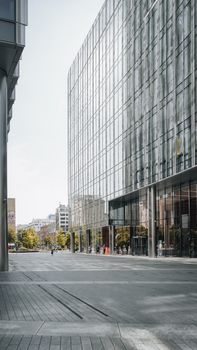 Contemporary glass skyscraper reflecting cityscape in Warsaw, showcasing urban architecture.