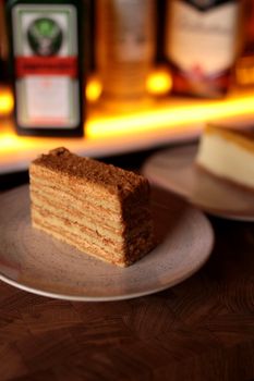 Close-up of a Medovik slice on a plate at a bar counter, perfect for dessert photography.