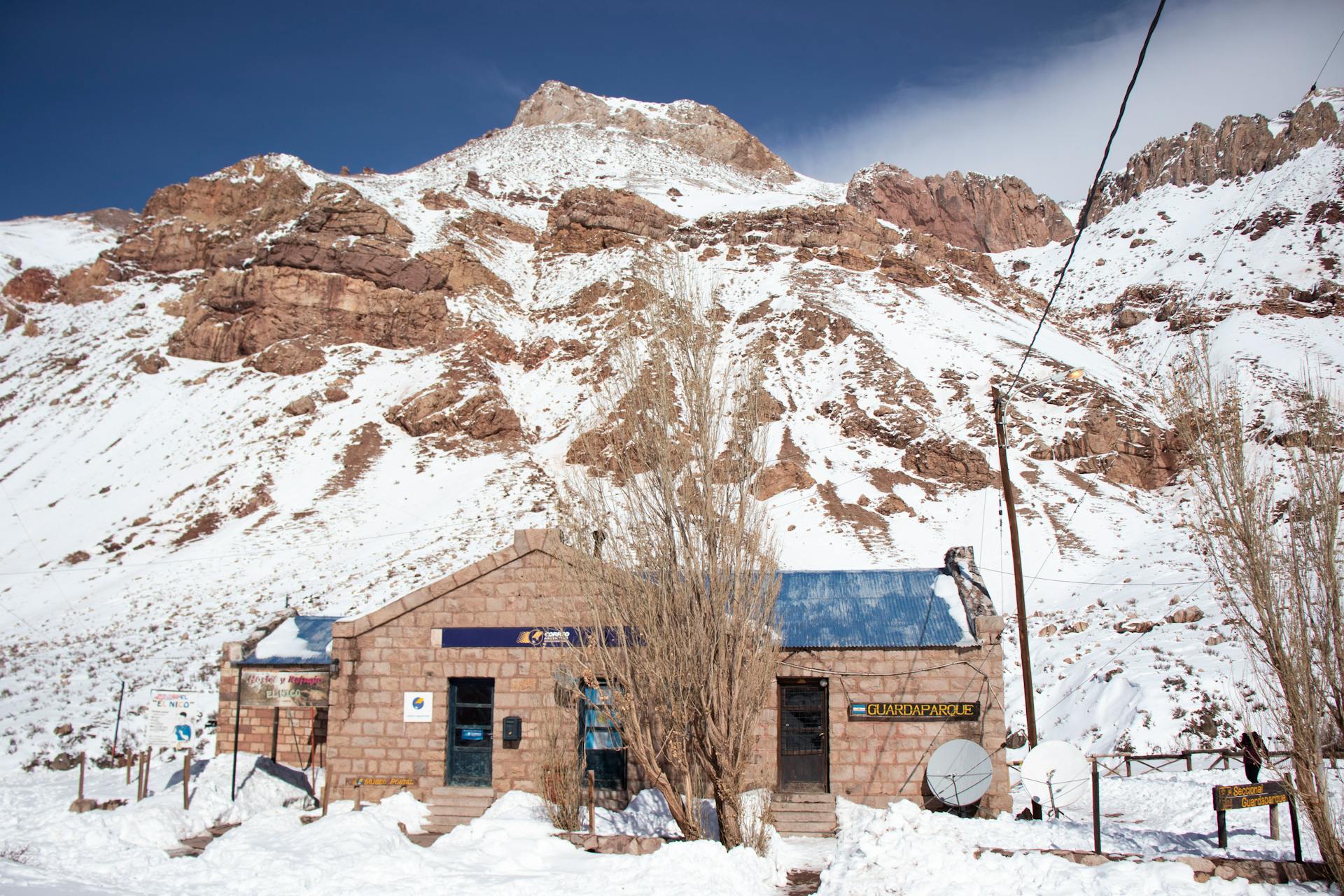Winter scene of a post office in Los Penitentes, Mendoza, Argentina, with snow-covered mountains.