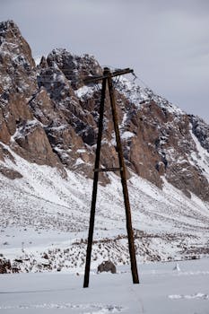 Snow-covered mountains with an electric post in Los Penitentes, Argentina.