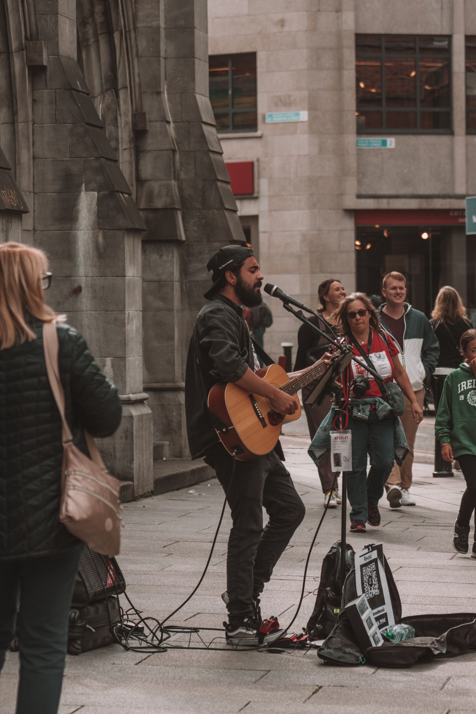 A street musician playing guitar for people in Dublin