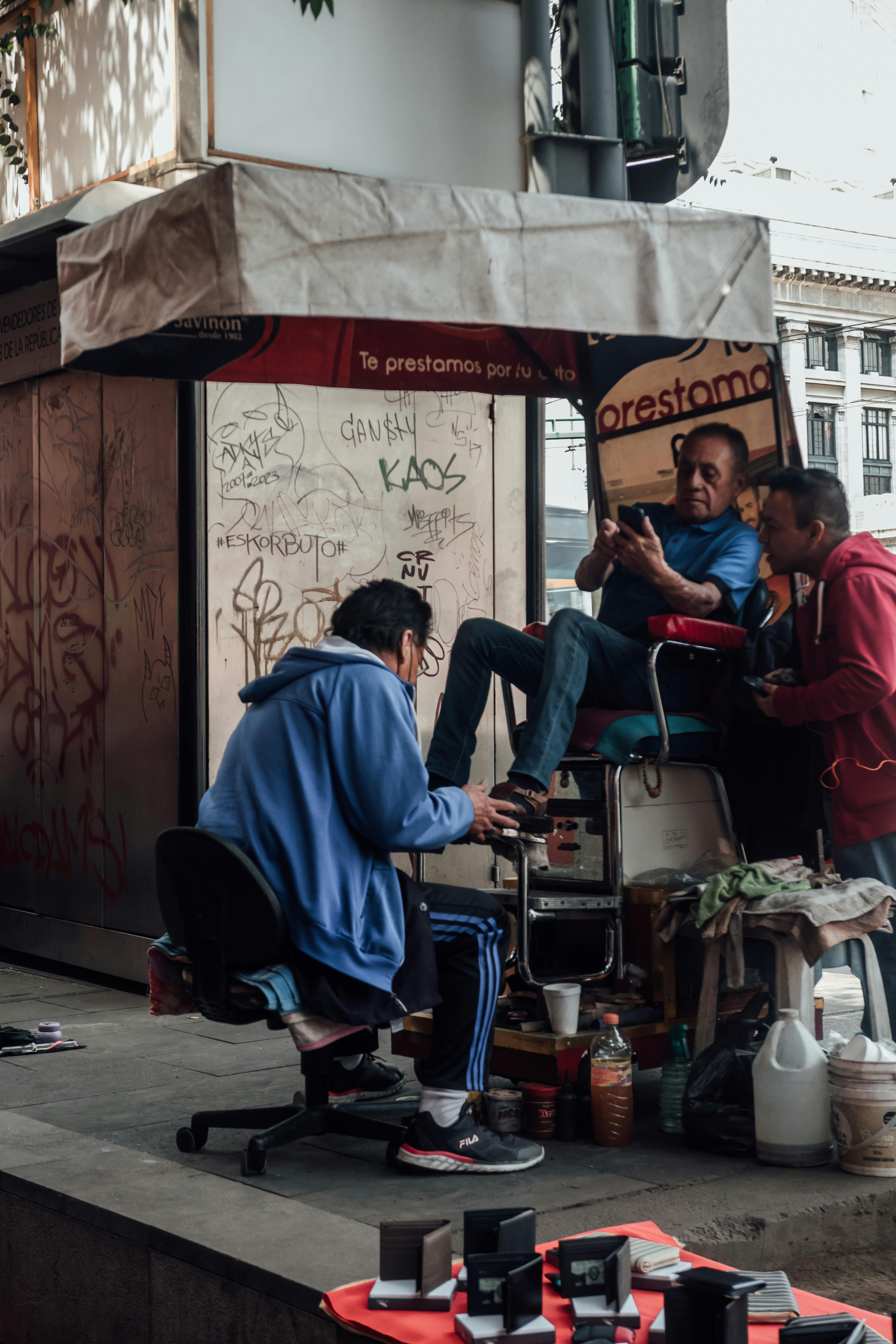 man cleaning shoes on a street