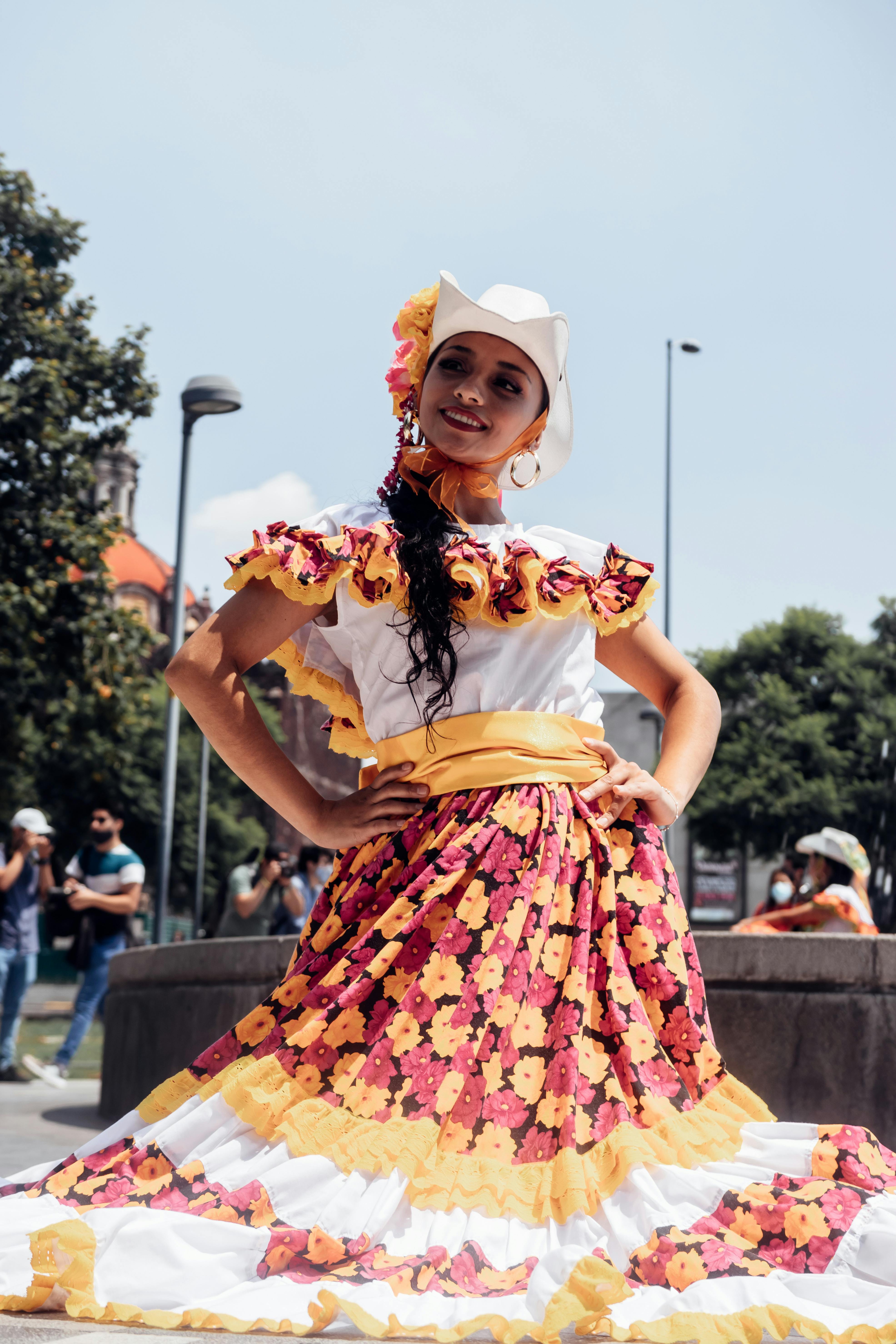 Woman in Yellow and Red Floral Dress Standing on Street · Free Stock Photo