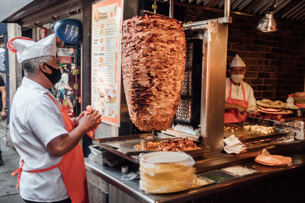 Man Cooking Meat on Skewer in Street Restaurant