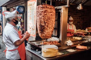 Man Cooking Meat on Skewer in Street Restaurant