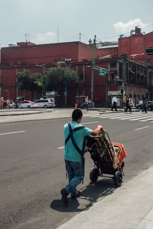 Man Pushing a Hand Truck on the Street