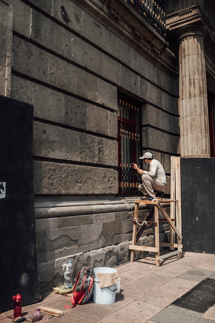 Man Painting A Window Grill