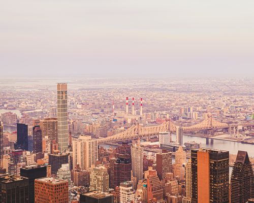 Free A breathtaking aerial view of New York City with the iconic Queensboro Bridge and Manhattan skyline at sunset. Stock Photo