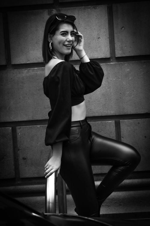 Free Stylish woman posing in black outfit outdoors showcasing urban fashion flair. Stock Photo