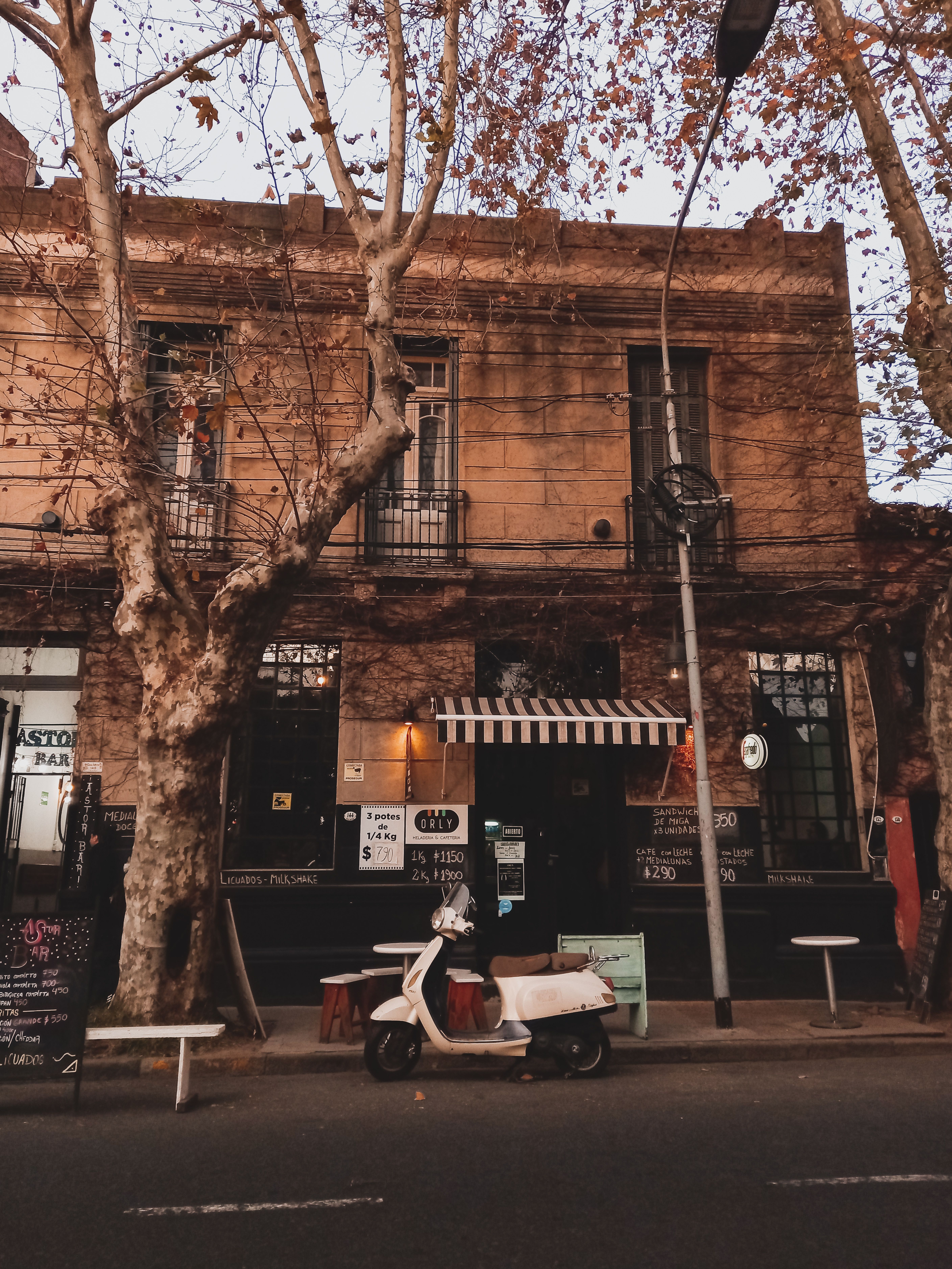 Charming Buenos Aires cafe exterior with a parked scooter, highlighting retro architecture and cozy vibes.