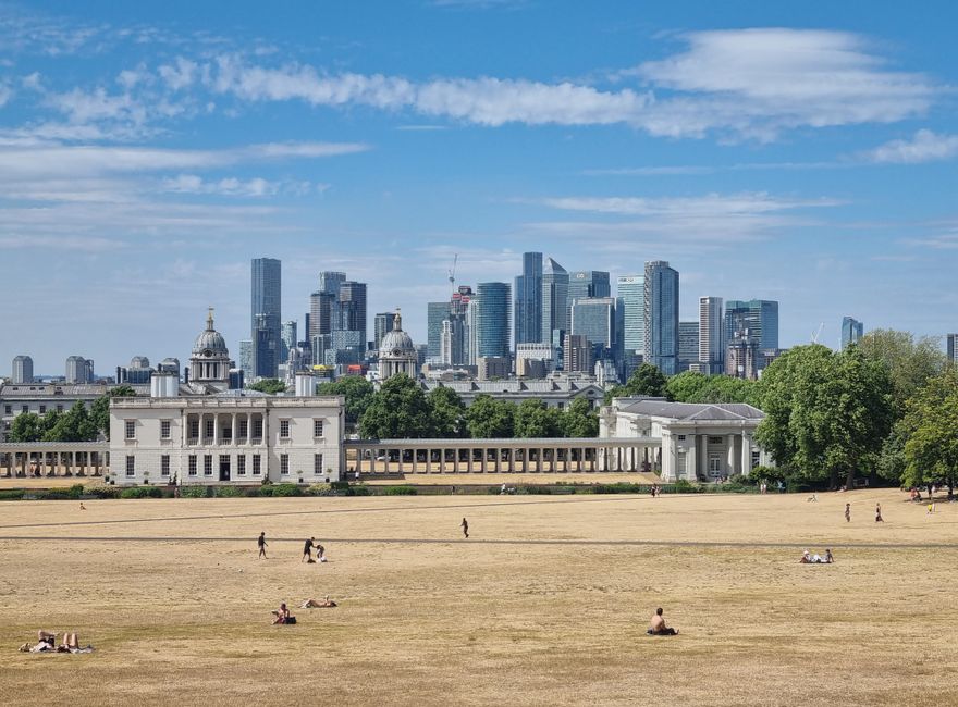 Scenic view of London's skyline from Greenwich Park on a sunny day.
