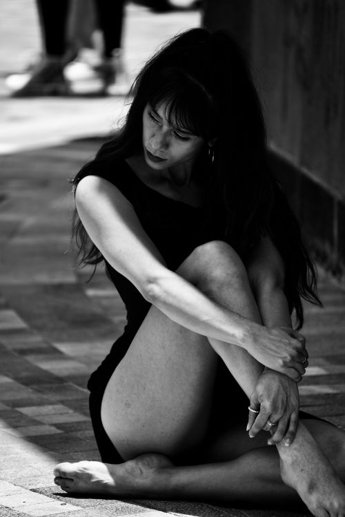 Free Artistic monochrome portrait of a woman sitting on the ground, evoking introspection. Stock Photo