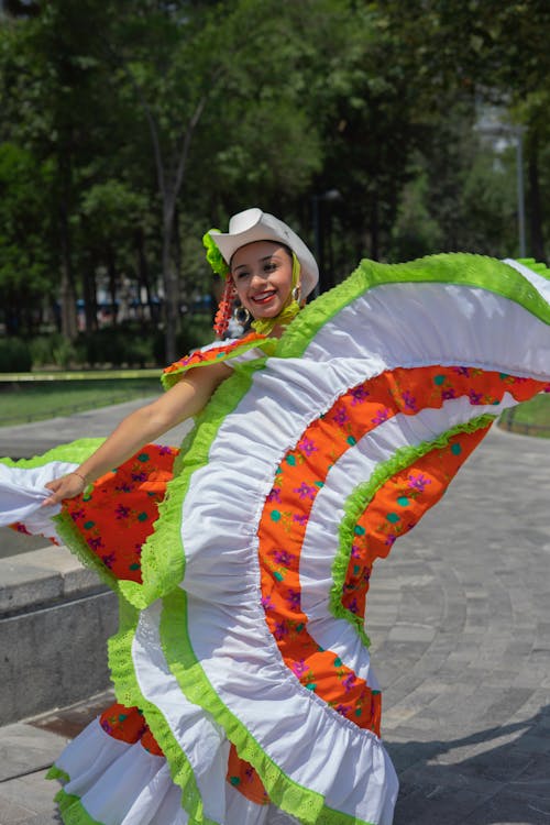 Woman Dancing while Wearing a Colorful Floral Dress