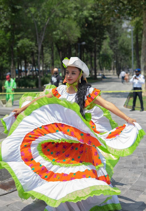 Woman Dancing in Floral Long Dress and White Hat