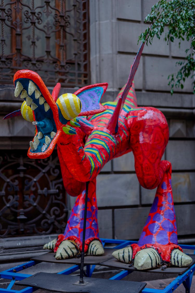 A Red Dragon Statue On Blue Steel Rack