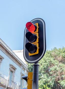 Close-up of a red traffic light against a clear sky in Ciudad de México.