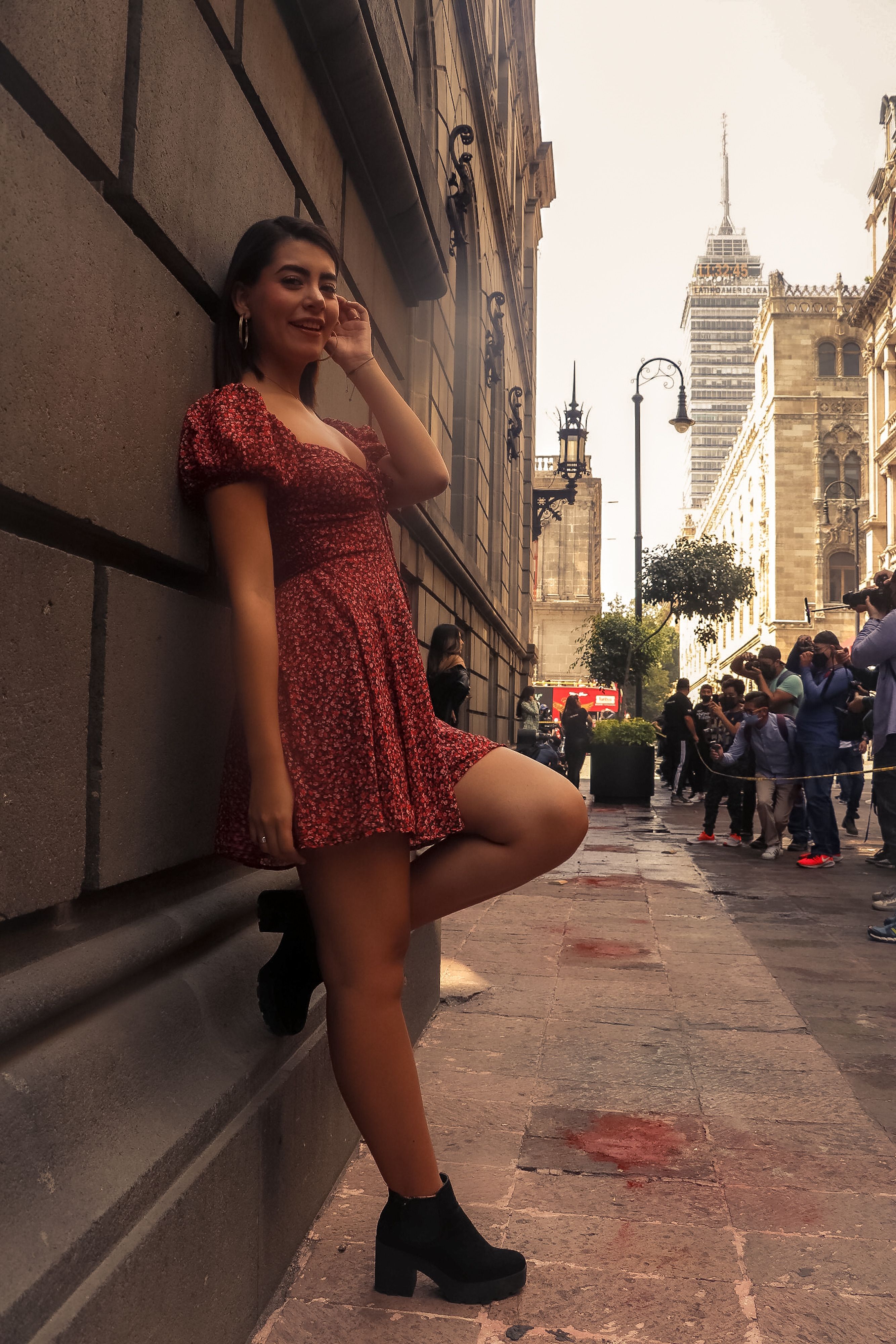 Stylish young woman posing confidently against a historic facade in downtown Mexico City, capturing urban charm.
