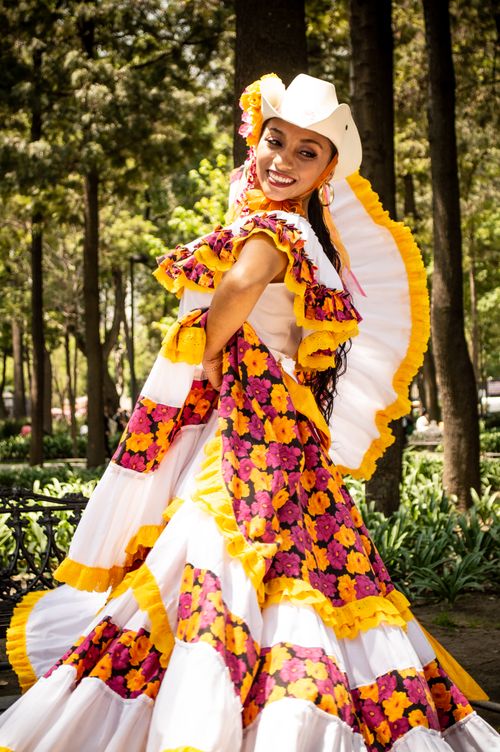 Free Vibrant traditional Mexican dress in a sunlit forest setting, showcasing culture and joy. Stock Photo