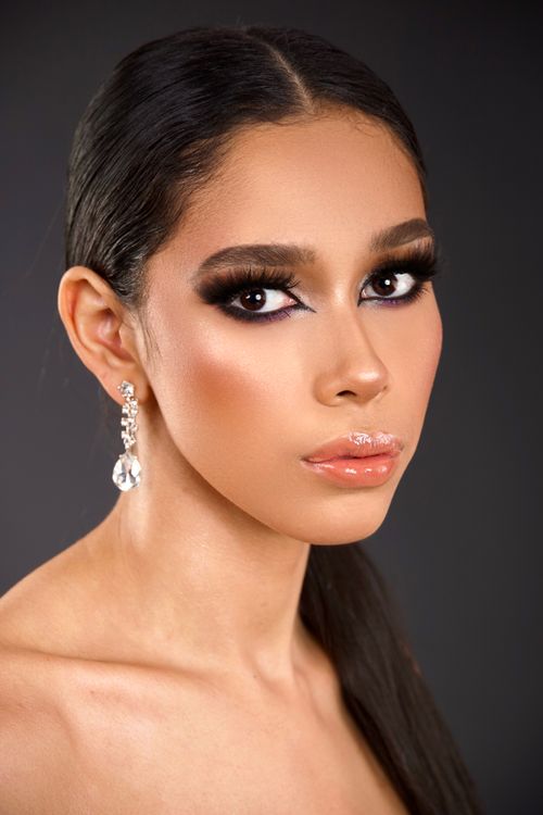 Free Close-up portrait of a woman with stunning makeup and earrings on a dark background. Stock Photo