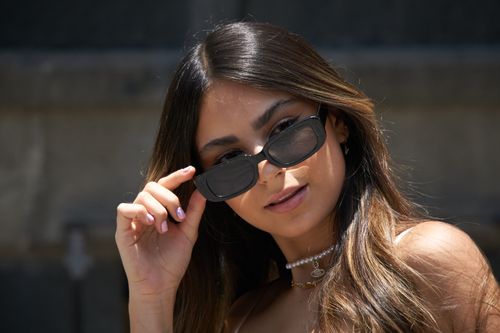 Free Close-up portrait of a fashionable woman with sunglasses enjoying a sunny day outdoors. Stock Photo