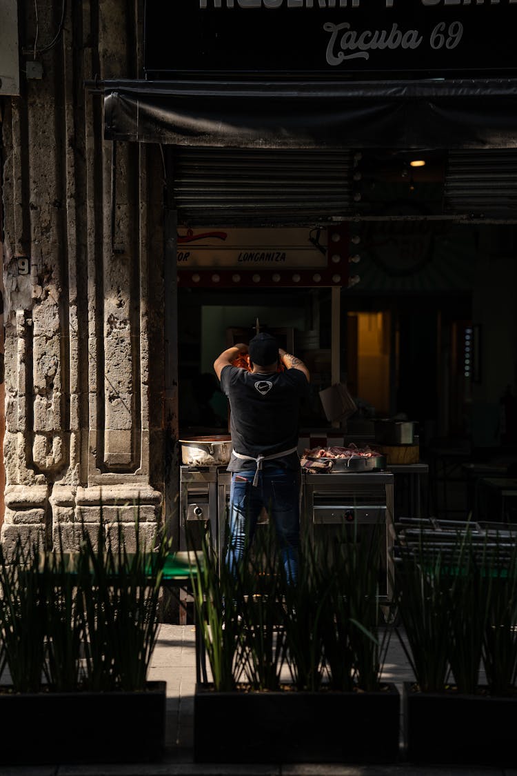 Man Standing And Preparing Food At A Food Stand