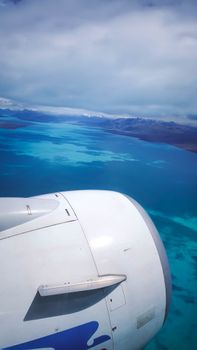 Aerial view of a jet engine flying over vibrant blue waters near Santa Cruz, Argentina.