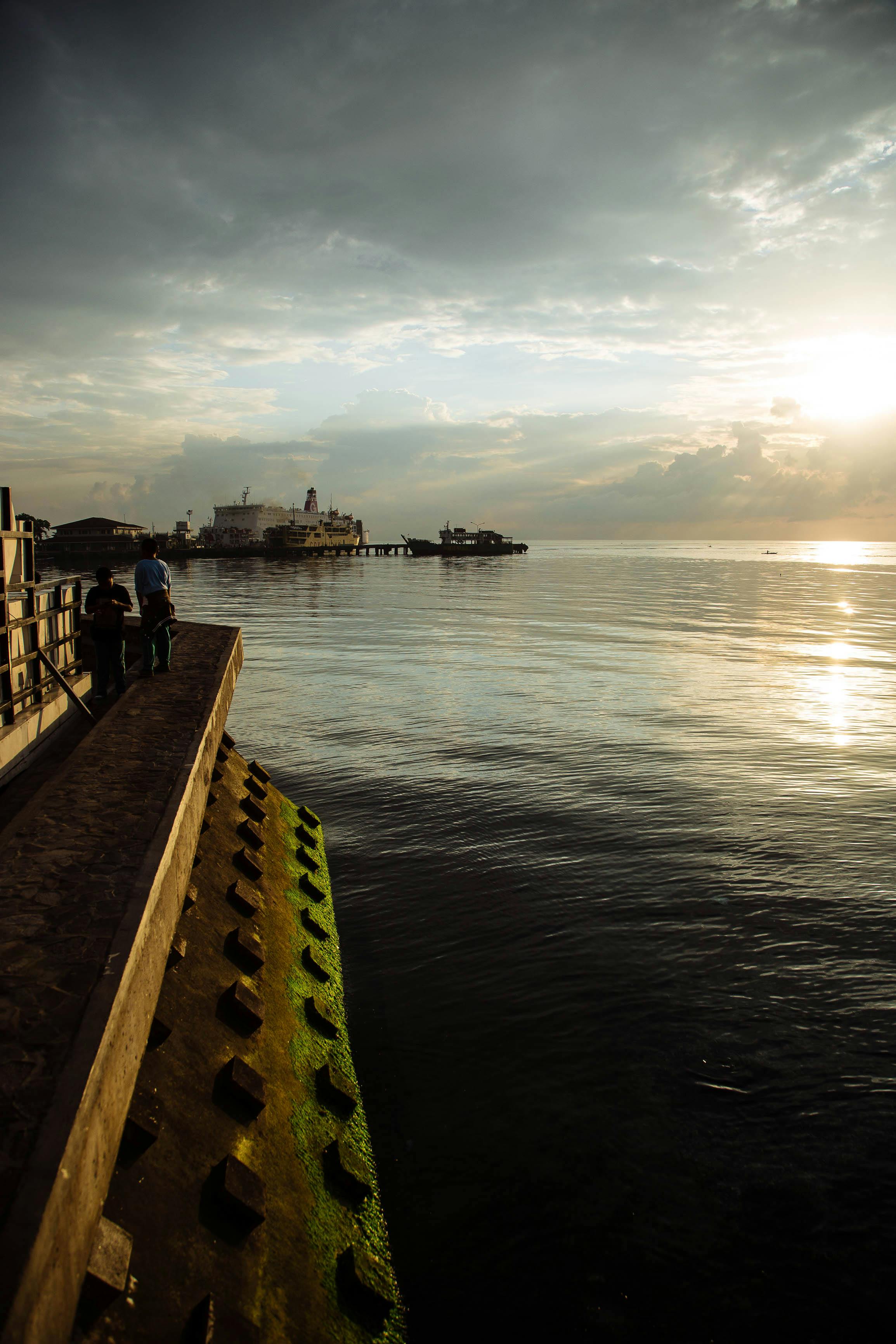 Artistic intimate silhouette of a couple in deep embrace during warm summer rain glow