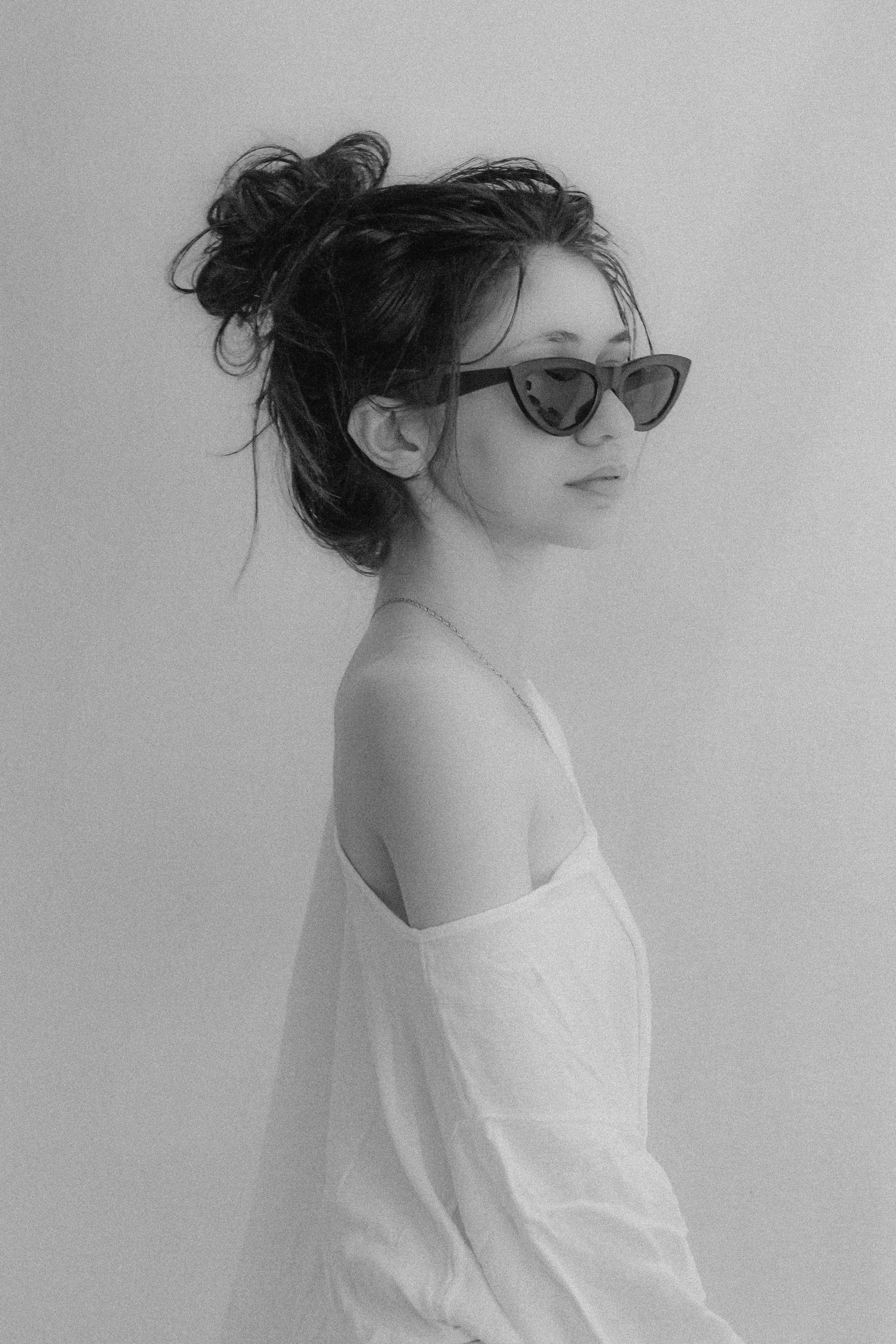 Stylish black and white portrait of a woman with messy hair and sunglasses in Aracati, Brazil.