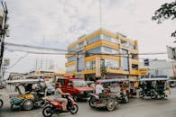 城市街景中，三轮车和各种车辆展示了繁华的城市环境