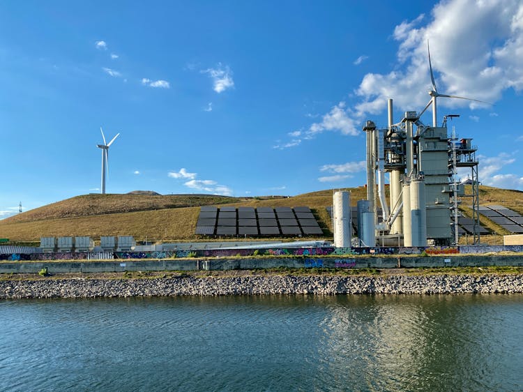 Solar Light Panels On Grass Near Windmills