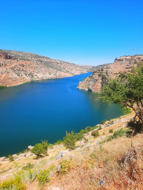 Free Explore the breathtaking landscape of Eğil Dam Lake bordered by rugged hills and a clear blue sky. Stock Photo