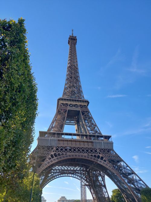 Free A low-angle view of the iconic Eiffel Tower in Paris, France under a bright blue sky. Stock Photo