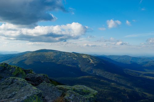 Free Serene mountain landscape with a vibrant blue sky and fluffy white clouds. Stock Photo