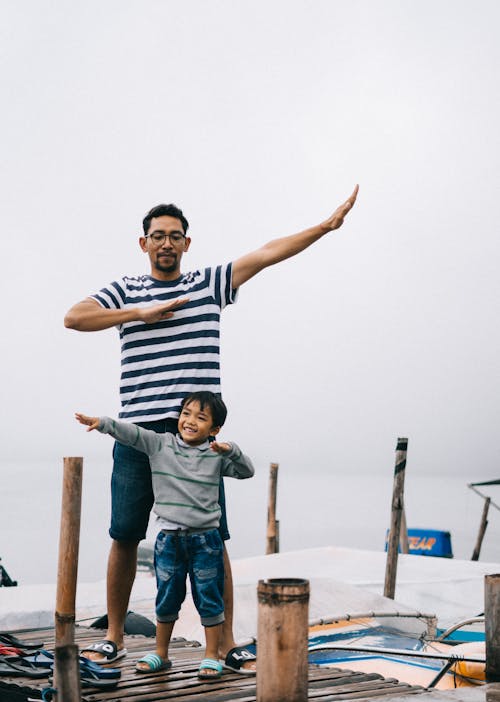 Père Et Fils Posant Sur Un Quai En Bois