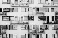 一张黑白照片，展示了现代公寓的外观和玻璃阳台