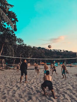 日落美景下，朋友们在充满活力的沙滩上打排球