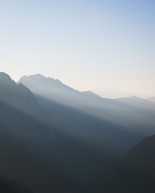Free Captivating mountain scene with mist and sunlight creating a mystical foggy atmosphere. Stock Photo