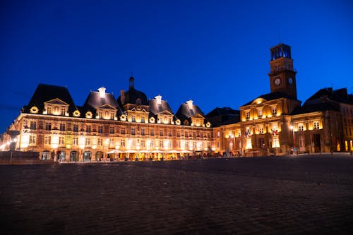 City Square with Illuminated Townhouses against Blue Sky at Dusk