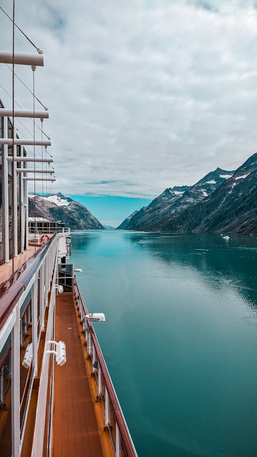 A Brown and White Ship Cruising on the Sea Near Mountain