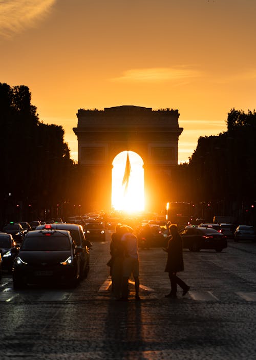 Free Sunlight Shining Through Arc de Triomphe at Sunset Stock Photo