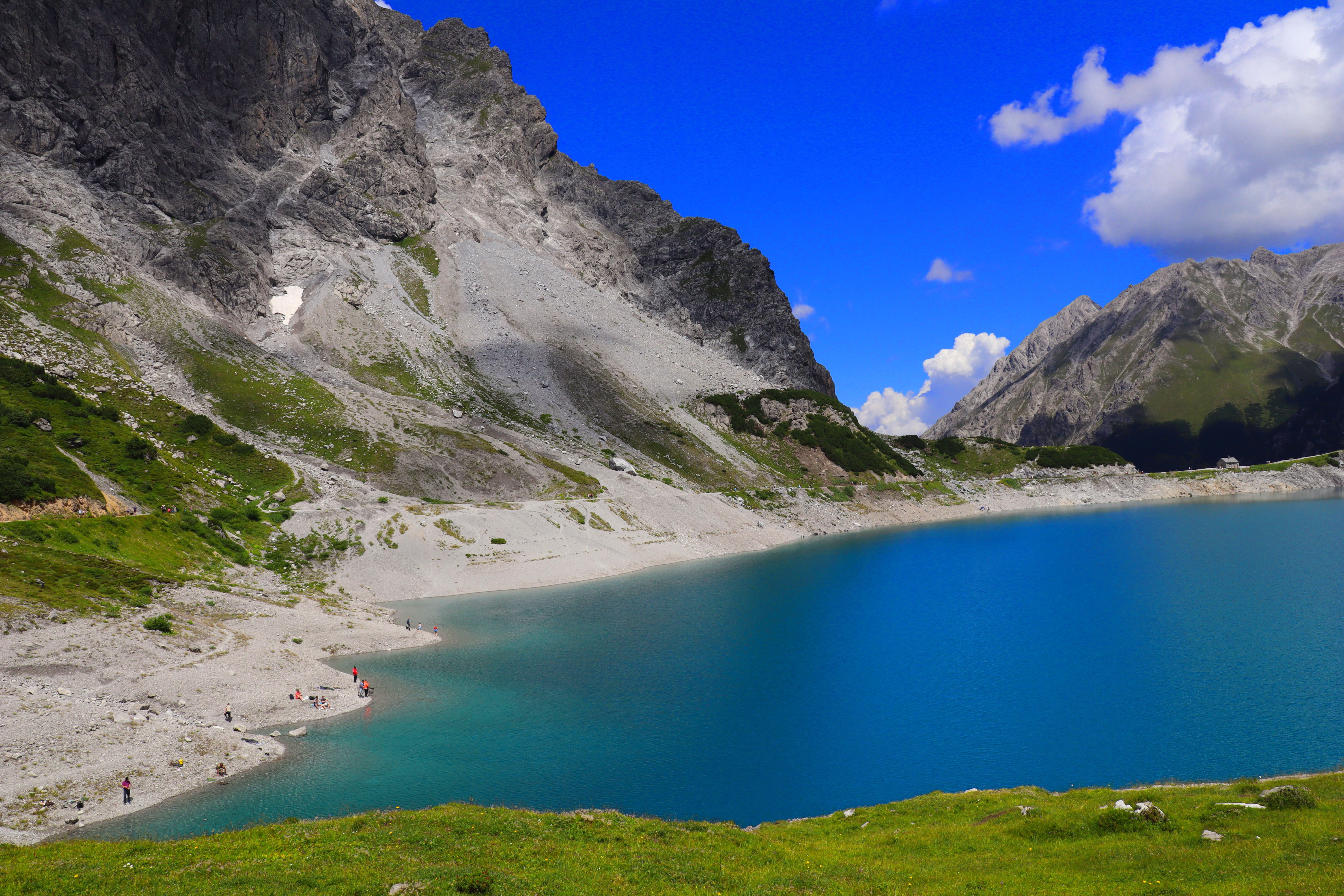 A stunning mountain landscape featuring a tranquil lake and clear blue skies.