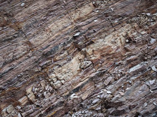 Free Close-up view of a textured, layered geological rock surface showcasing erosion and sedimentary features. Stock Photo