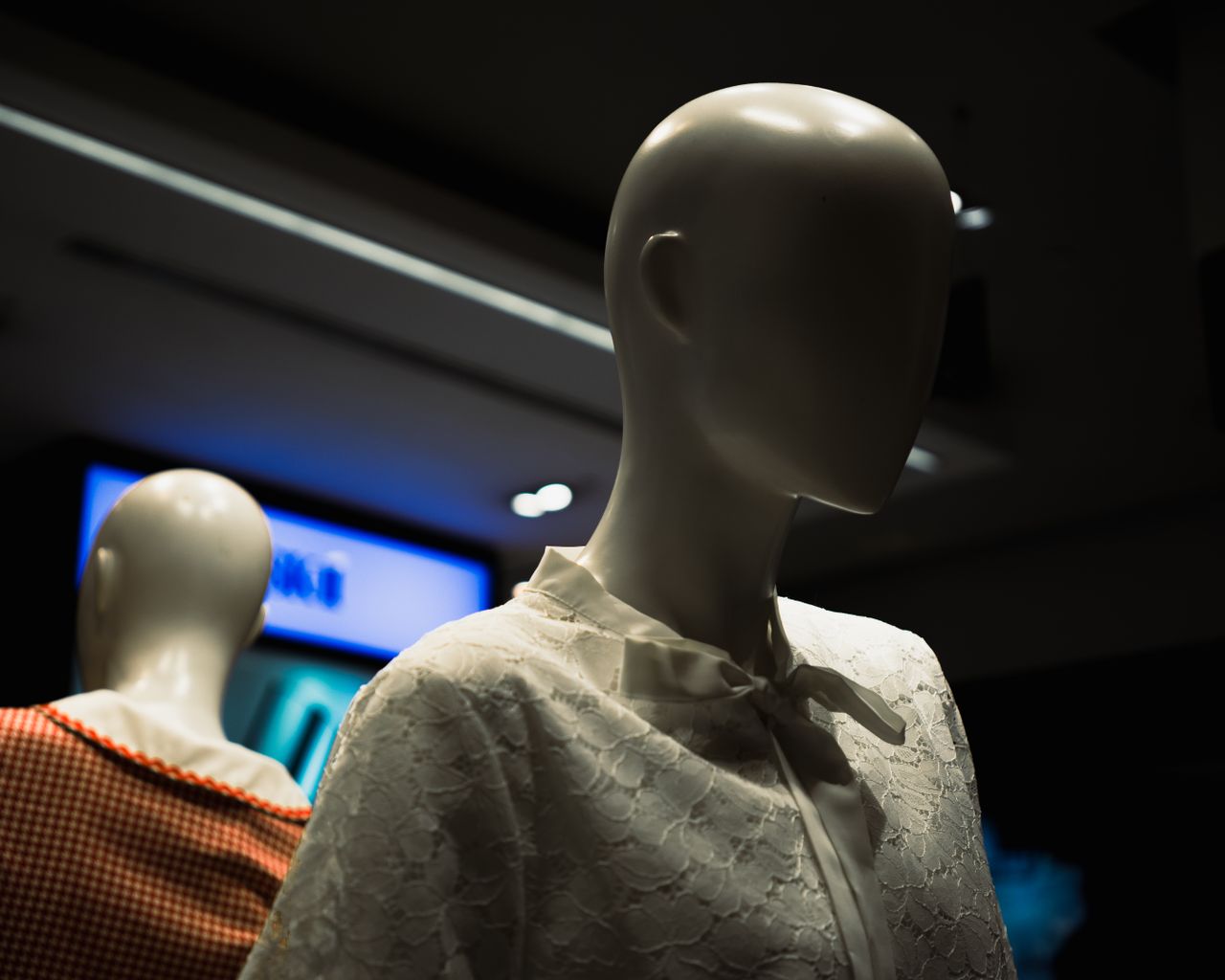 close up of faceless mannequins showcasing lace and gingham fashion in