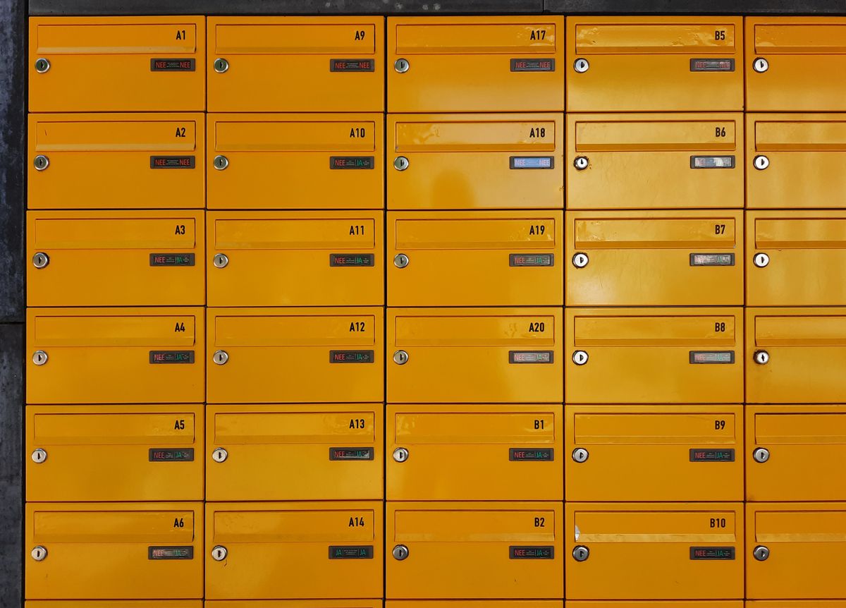 A wall of yellow post office boxes