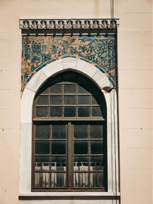 Elegant arched window with intricate molding and decorative stonework. Captures timeless architectural beauty.