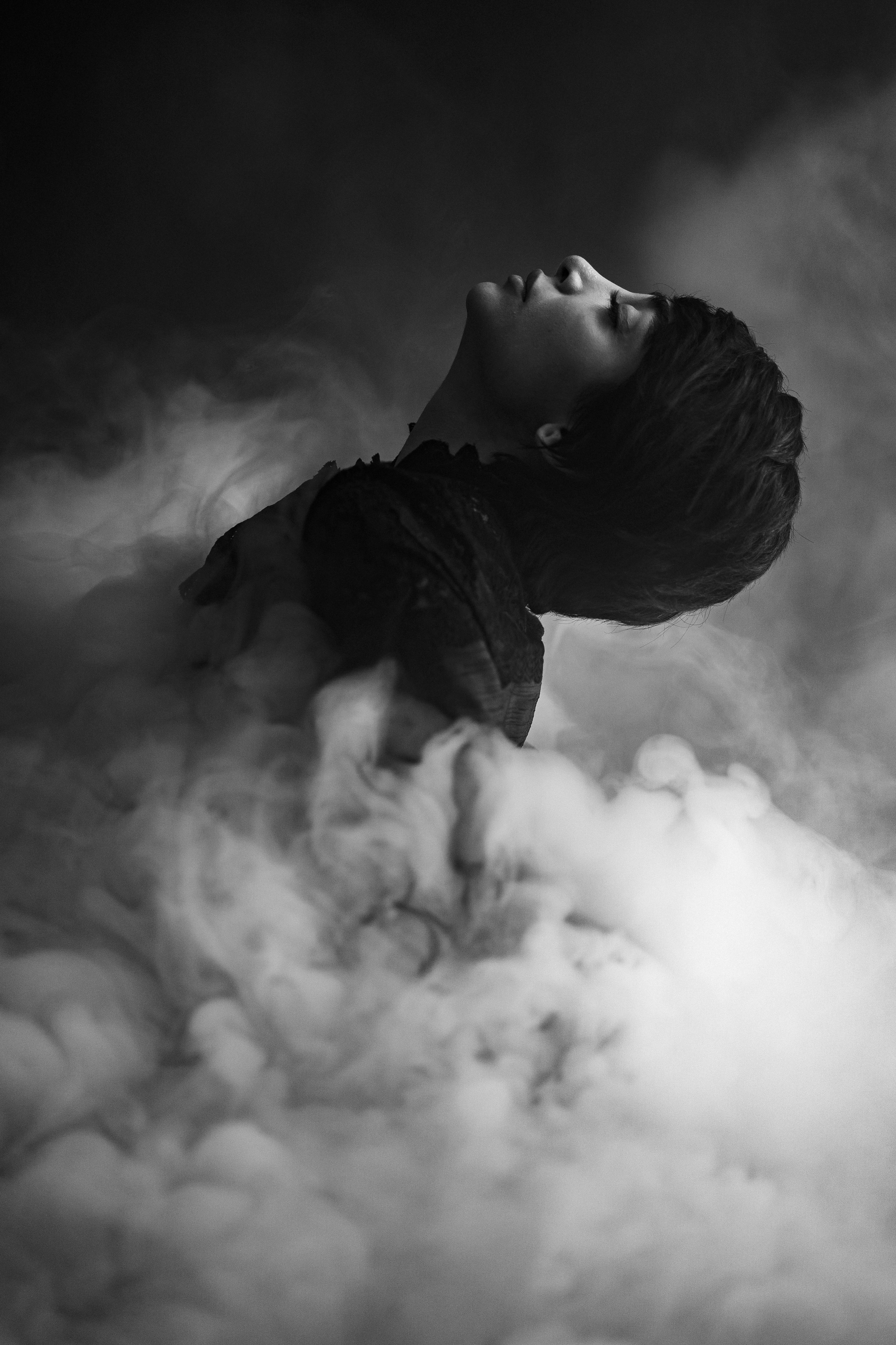 Dramatic black and white portrait of a woman enveloped in smoke, Paris.