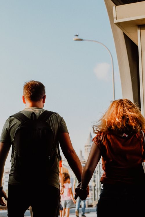 Free A couple holding hands, exploring the streets of Istanbul, Turkey under a clear sky. Stock Photo