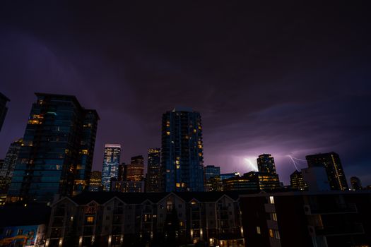 Captivating urban skyline at night, with striking lightning illuminating the city buildings.