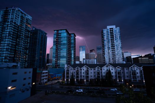 A striking cityscape of Calgary at night with lightning illuminating the skyline.