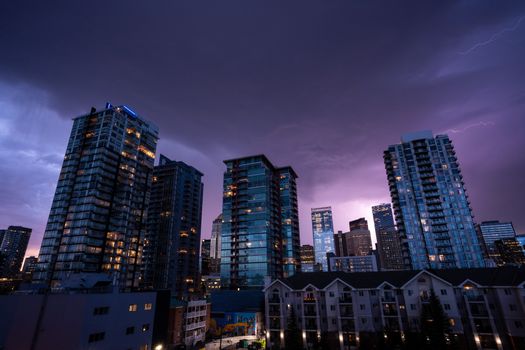 Captivating city skyline at night with striking lightning on the horizon.
